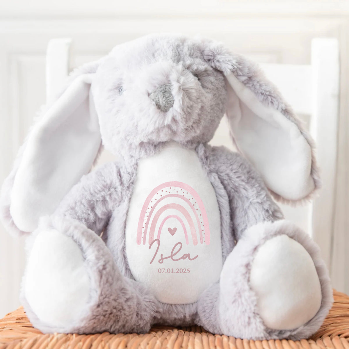 Grey soft bunny toy with personalised name and pink rainbow print on the front. A timeless keepsake by Ayla & Lara, perfect for baby gifts.