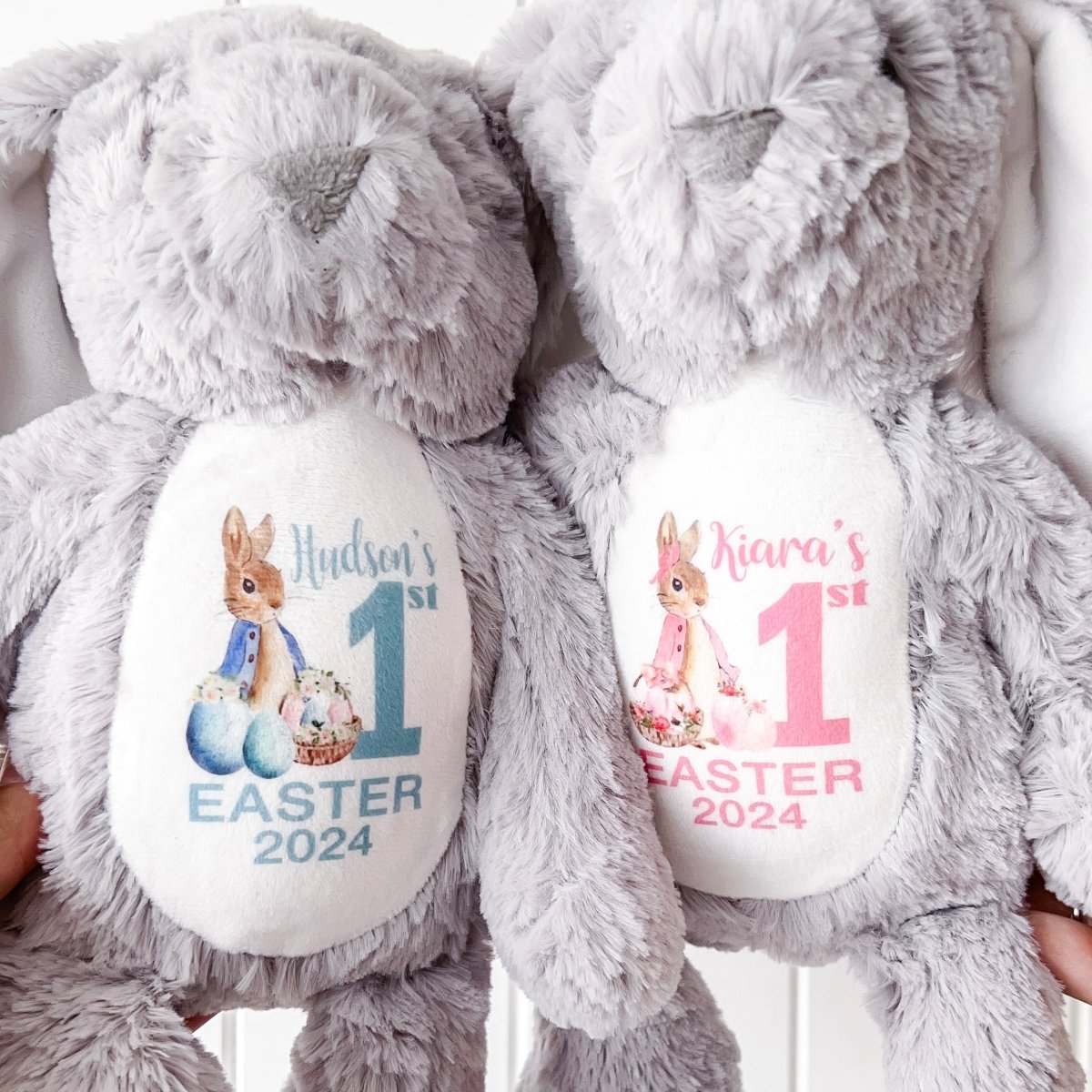 Two soft toy grey bunnies side by side celebrating with Peter Rabbit and Flopsy design "My First Easter 2025".