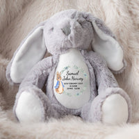 A soft grey bunny toy Jellycat lookalike, with a Peter Rabbit design of a new baby announcement 